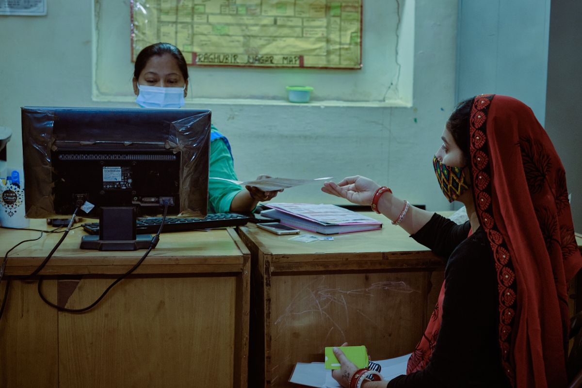 SEWA Shakti Kendra staff assisting a woman with documents and access to government services